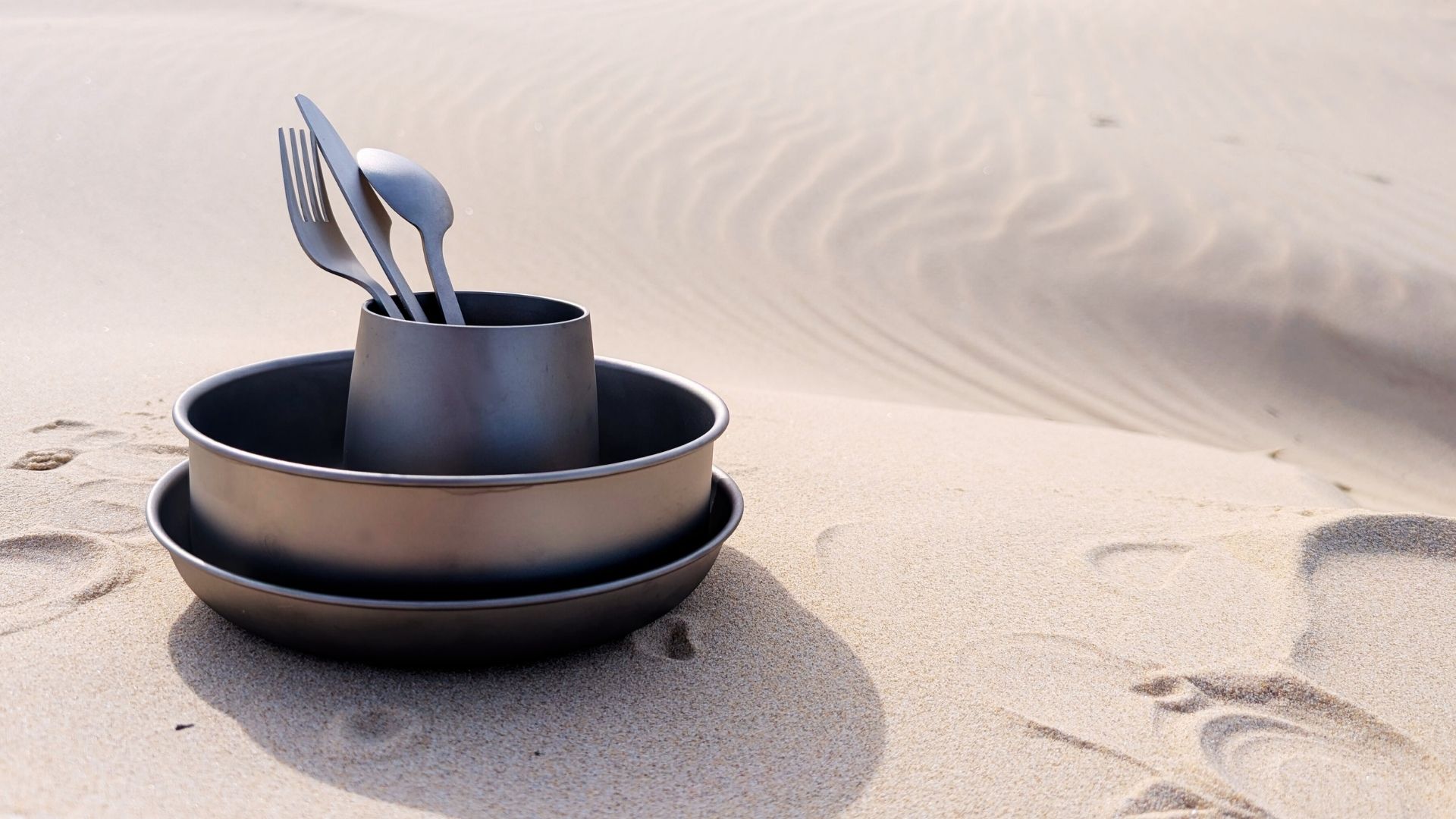 Titanium Set Featured Product Soulful Camper titanium camping set including lightweight plate, bowl, cup, and cutlery on natural outdoor background