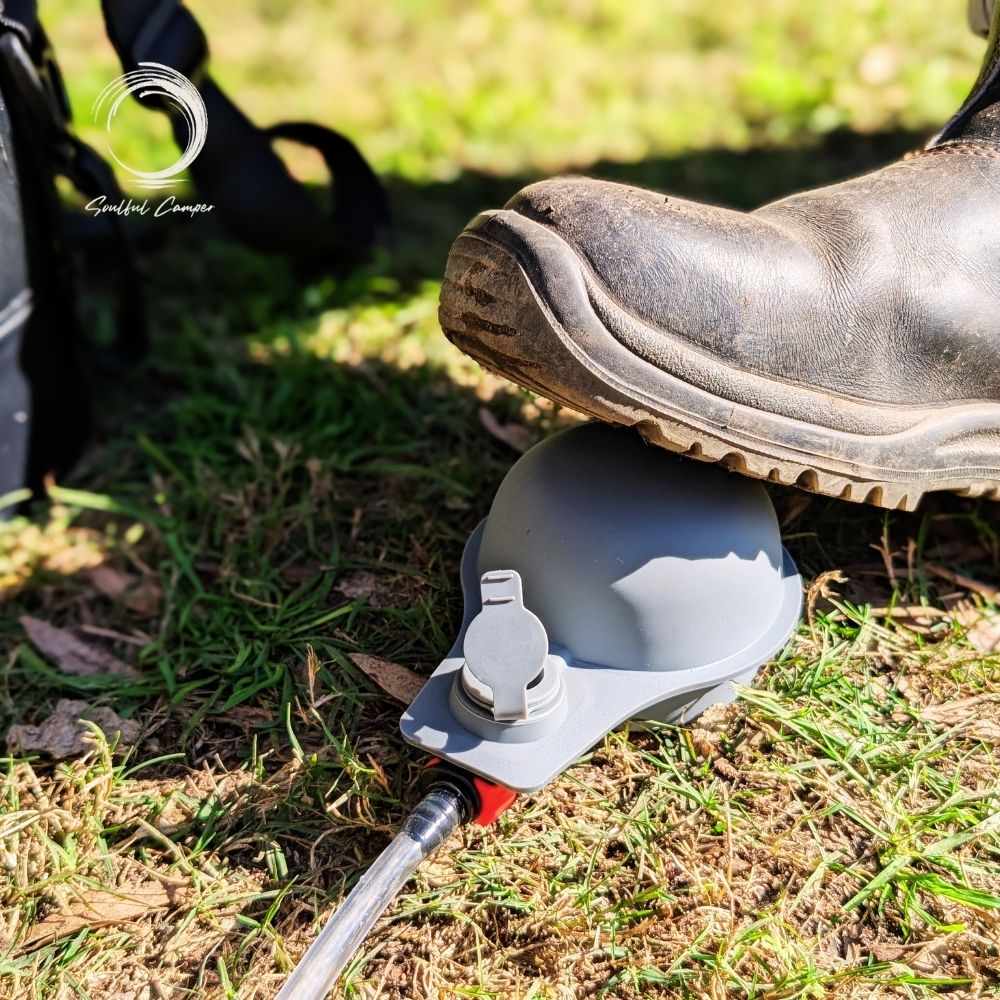 Boot pressing on foot pump of camping Sun Shower system