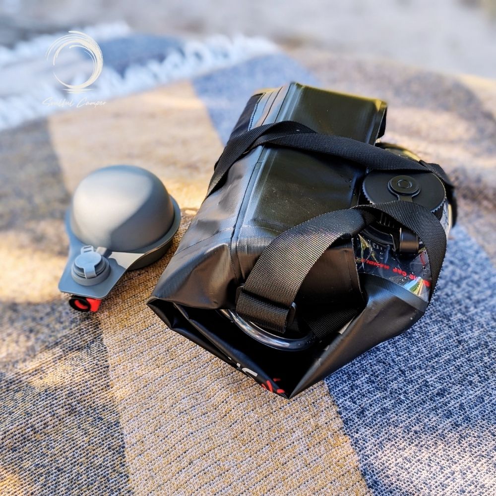 Folded Sun Shower with foot pump on picnic blanket