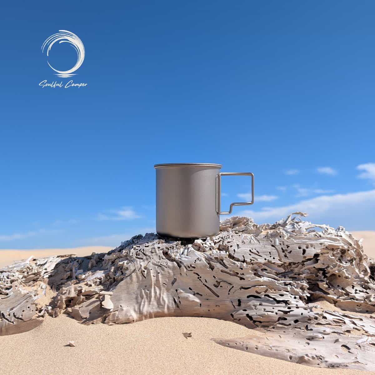 Fully stacked Ti-3 Mug Stack shown as a single compact titanium mug on driftwood, with two smaller mugs nested inside.